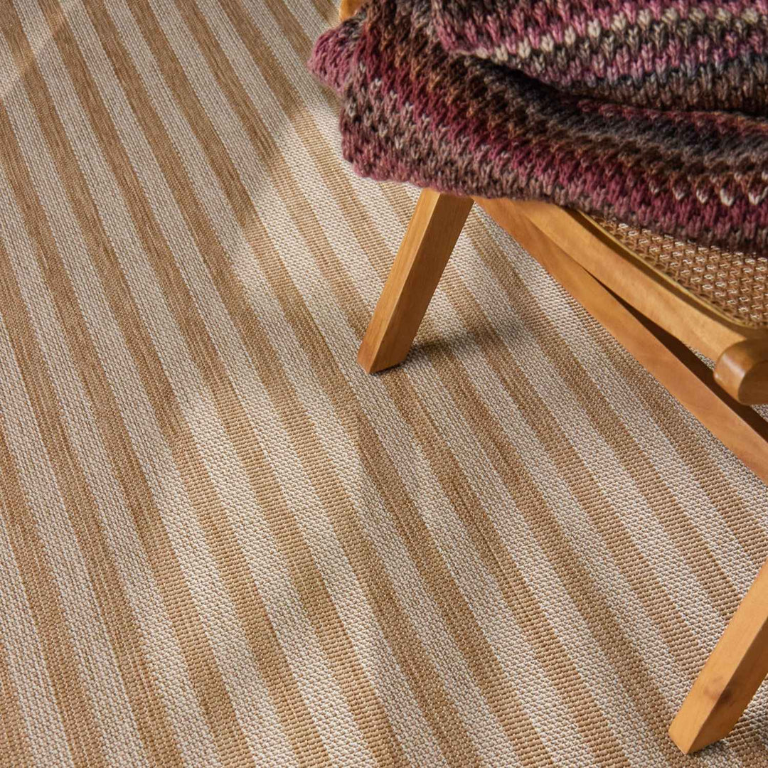 Striped carpet with a wooden chair and multicolored blanket
