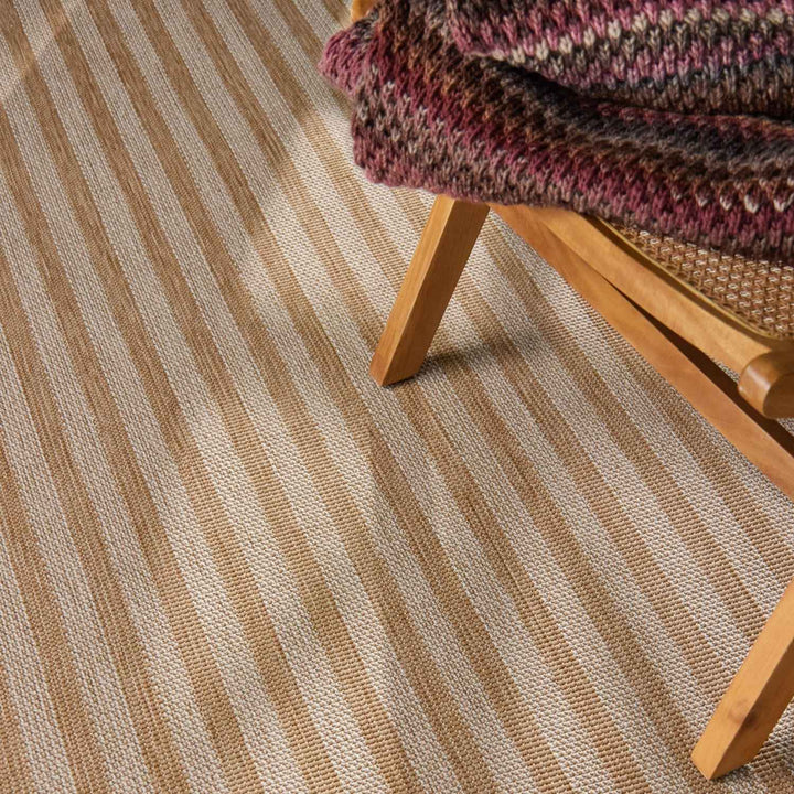 Striped carpet with a wooden chair and multicolored blanket