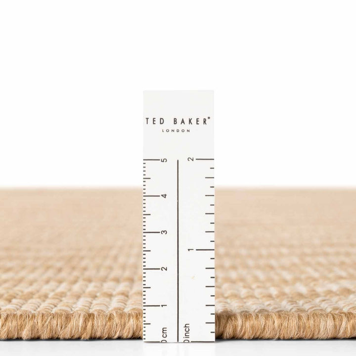 Beige fabric with a ruler and 'Ted Baker London' label on a white background