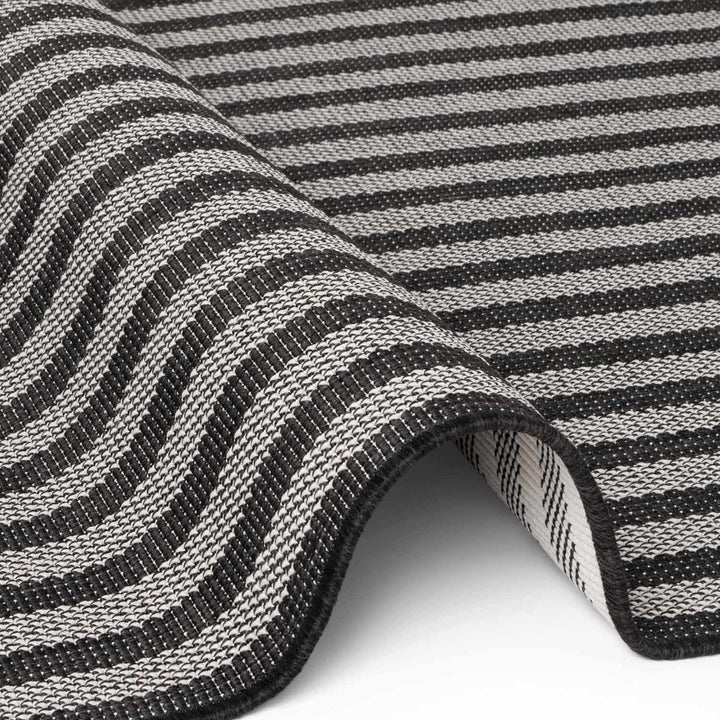 Close-up of a black and white striped fabric with a wavy pattern.