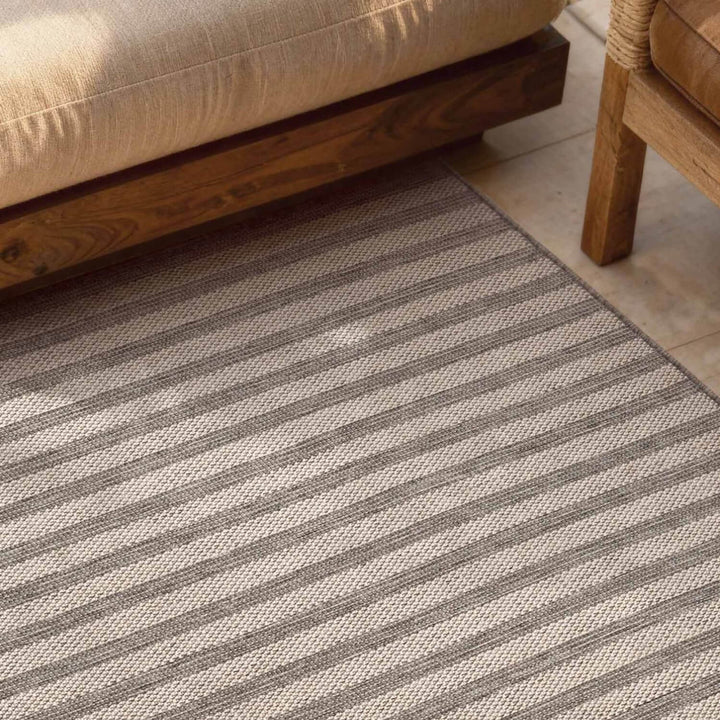Striped rug with a sofa and wooden furniture in the background