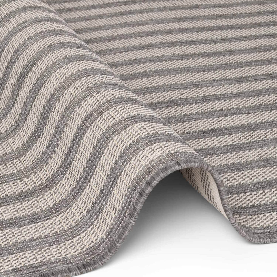 Close-up of a gray and beige striped fabric with a wavy pattern.