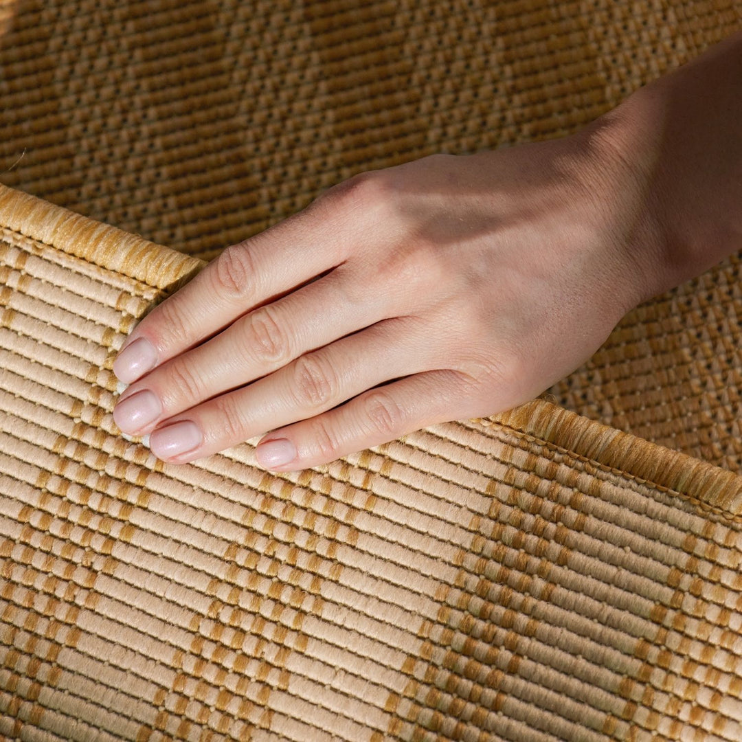 Hand resting on a woven mat with a warm color palette