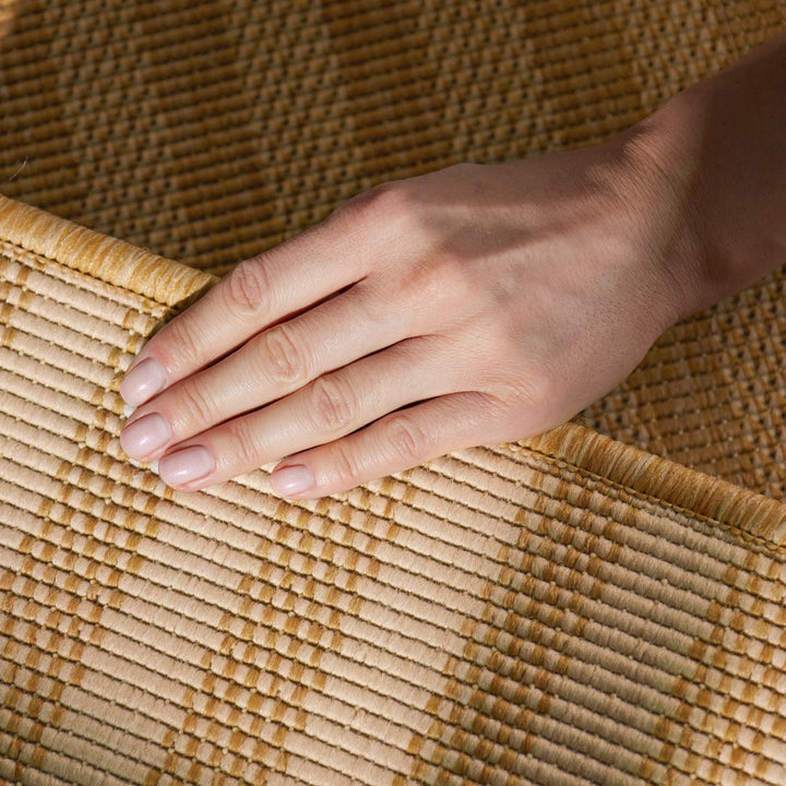 Hand resting on a woven mat with a warm color palette