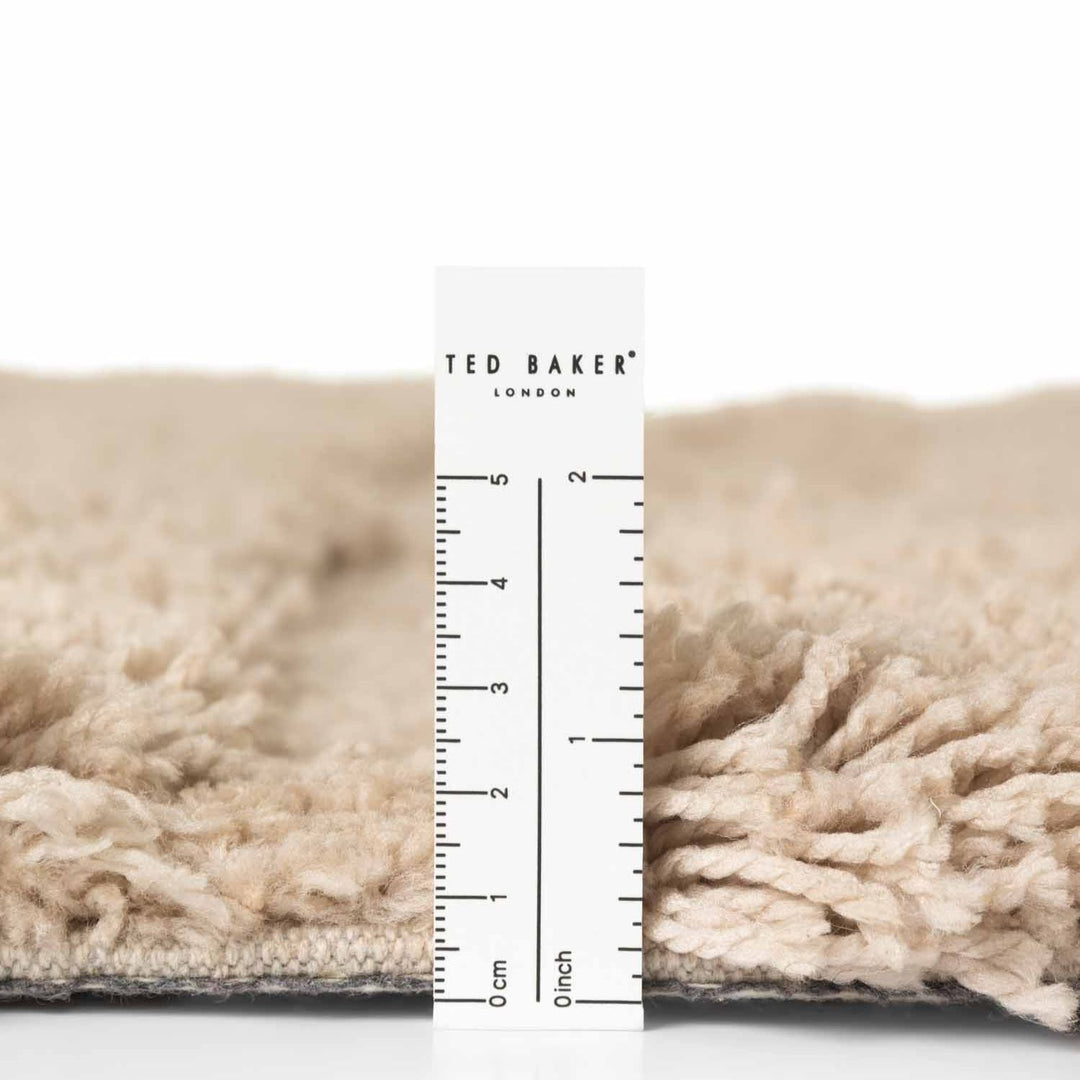Close-up of a textured fabric with a Ted Baker ruler overlay on a white background