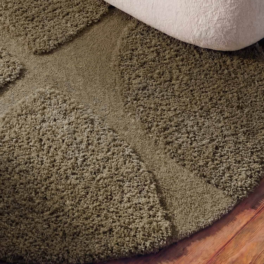 Brown shaggy rug on a wooden floor with a white baseboard.