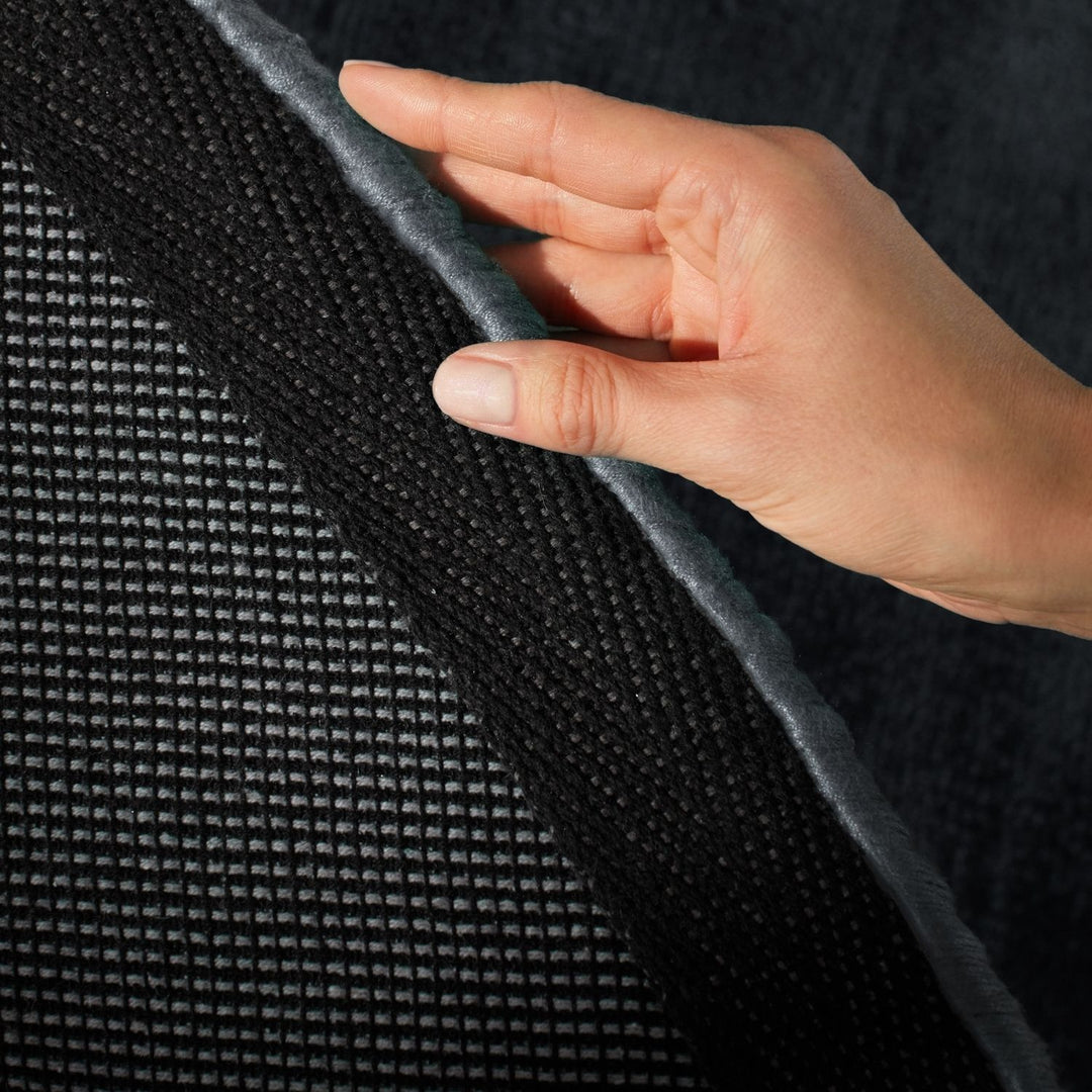 Hand touching a textured black surface