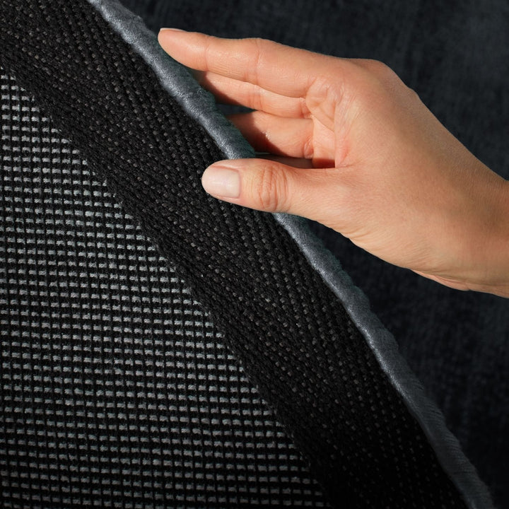 Hand touching a textured black surface