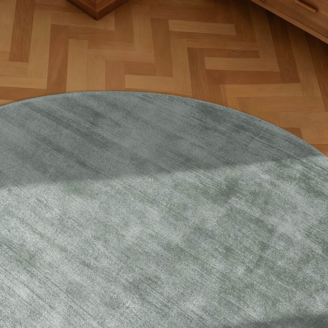 Round gray rug on a wooden floor