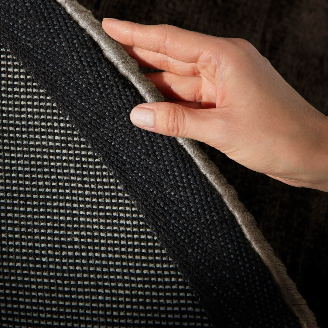 Hand touching a textured black surface
