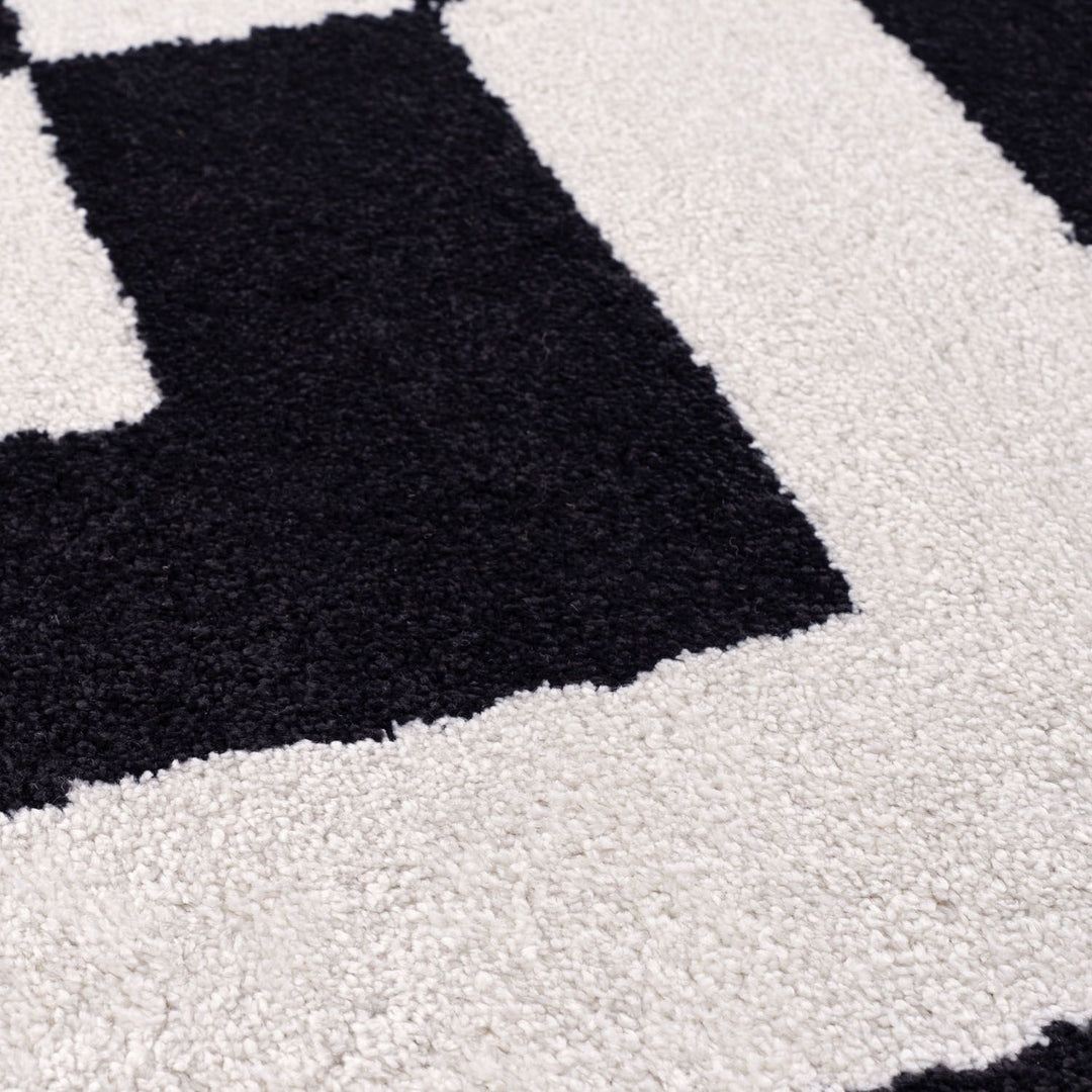 Close-up of a black and white checkered pattern on a textured surface.
