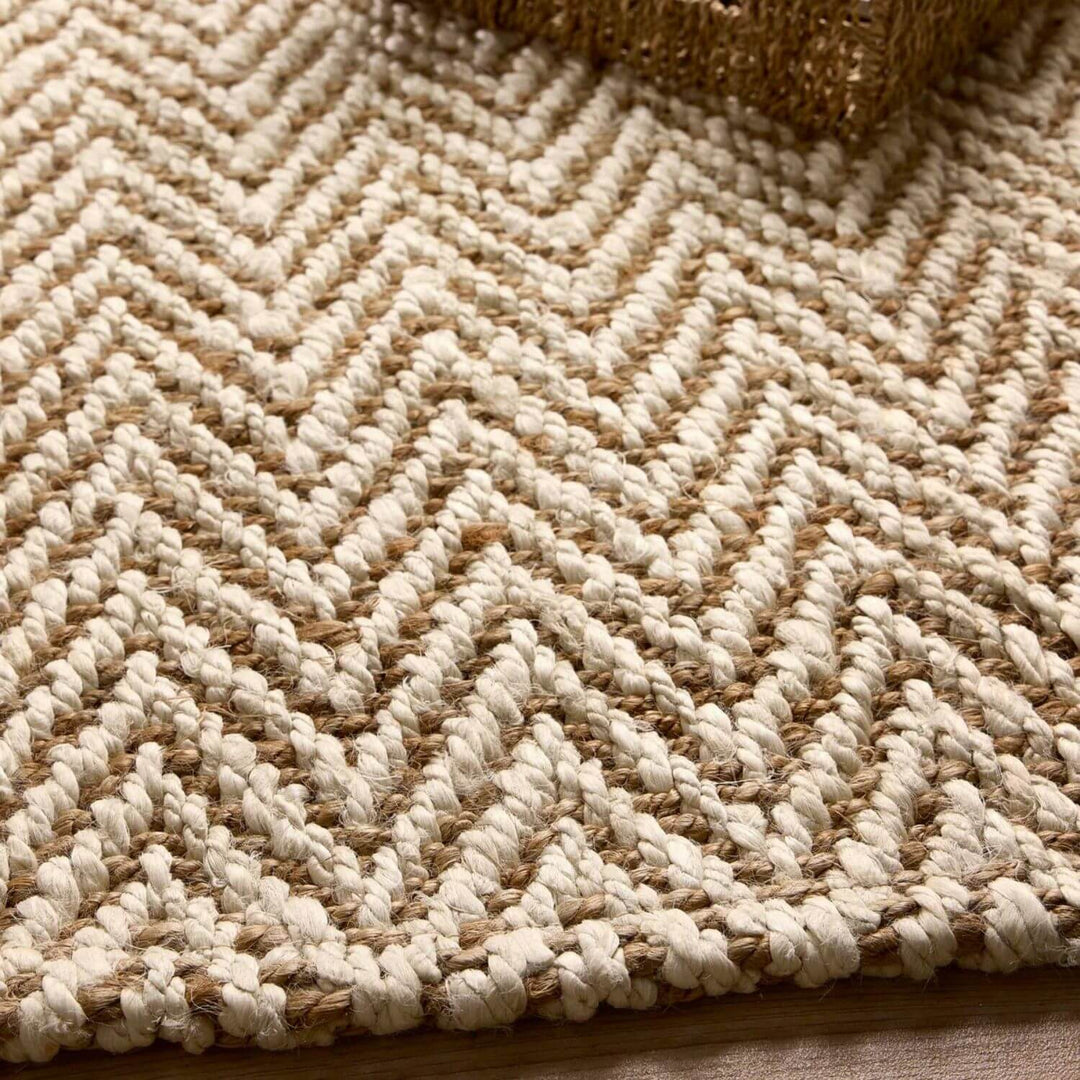 Close-up of a textured beige and brown rug with a herringbone pattern.