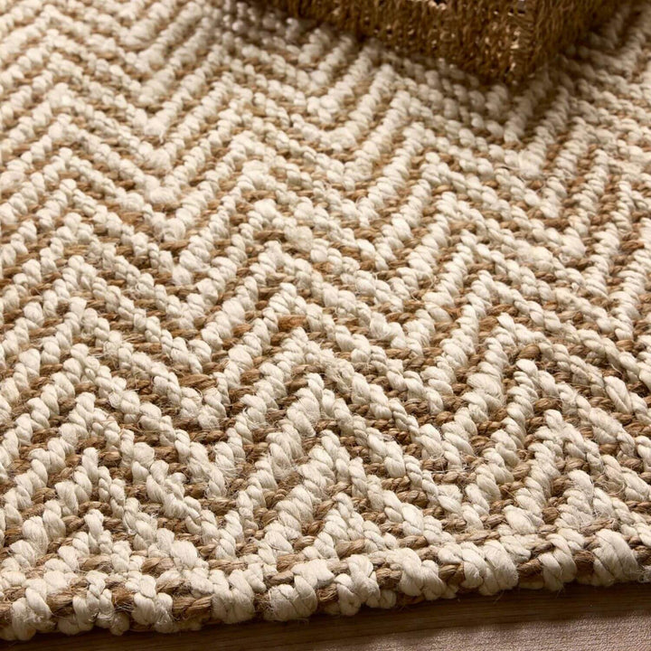 Close-up of a textured beige and brown rug with a herringbone pattern.