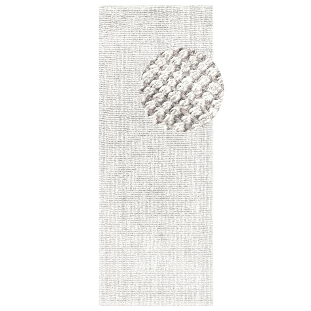 Textured white rug with a circular pattern on a plain background