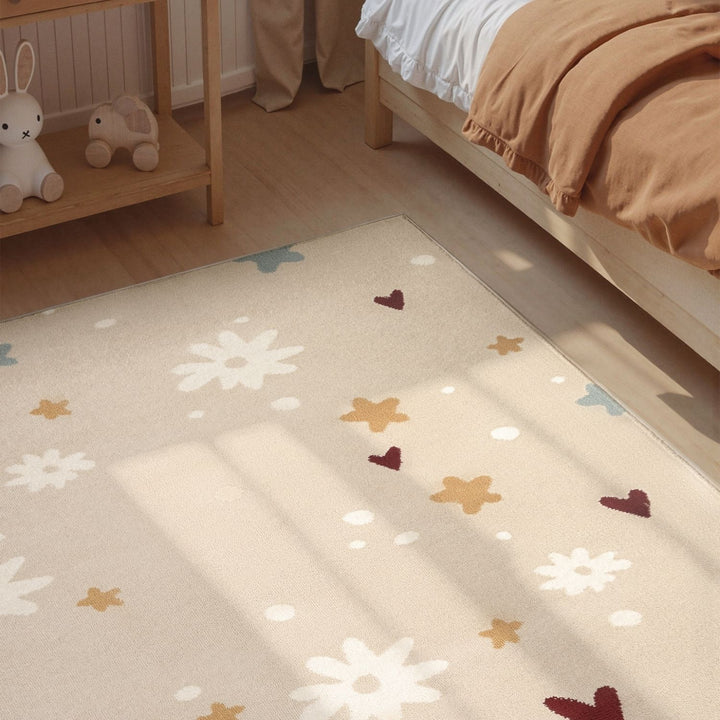 Children's room with a patterned rug featuring flowers and leaves on a wooden floor.