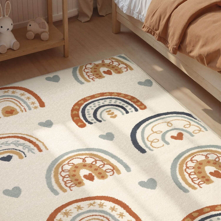 Children's room with a rug featuring rainbow and heart patterns.