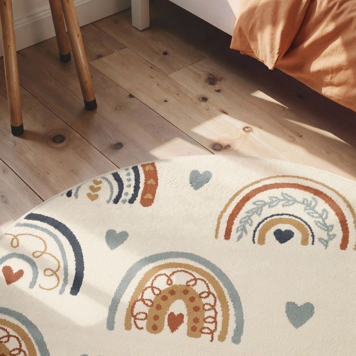 Decorative rug with rainbow and heart patterns on a wooden floor.