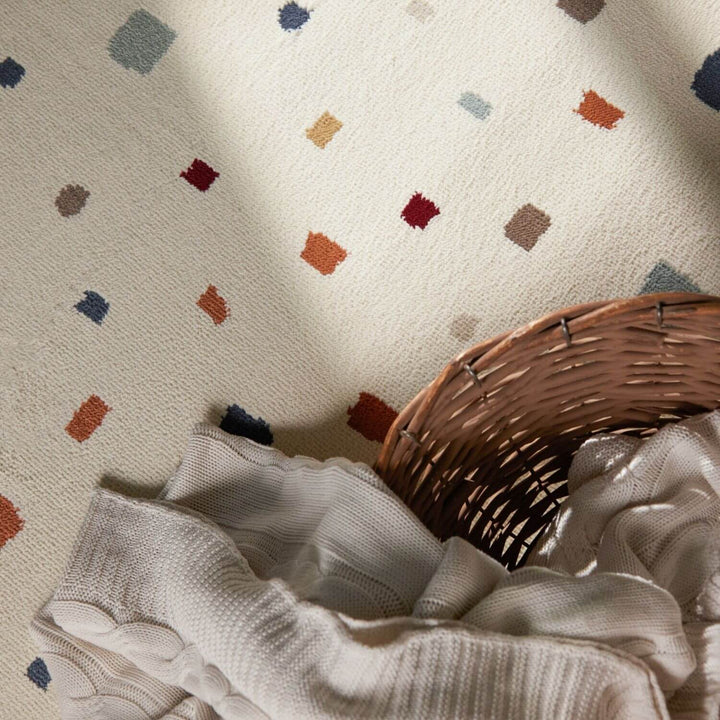 Textured fabric with colorful geometric patterns and a wicker basket on a neutral background