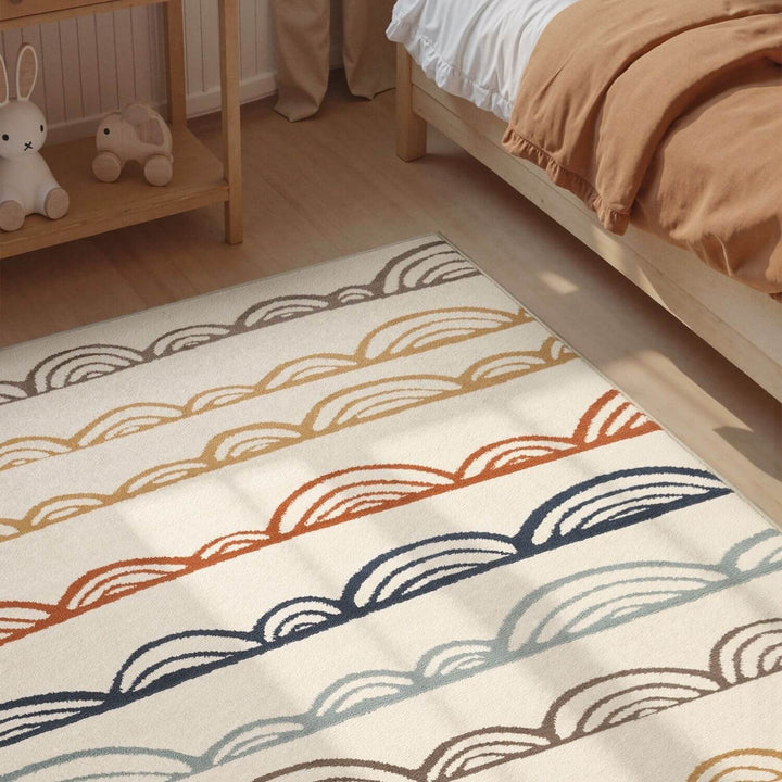 Colorful patterned rug on a wooden floor with a bed and shelf in the background.