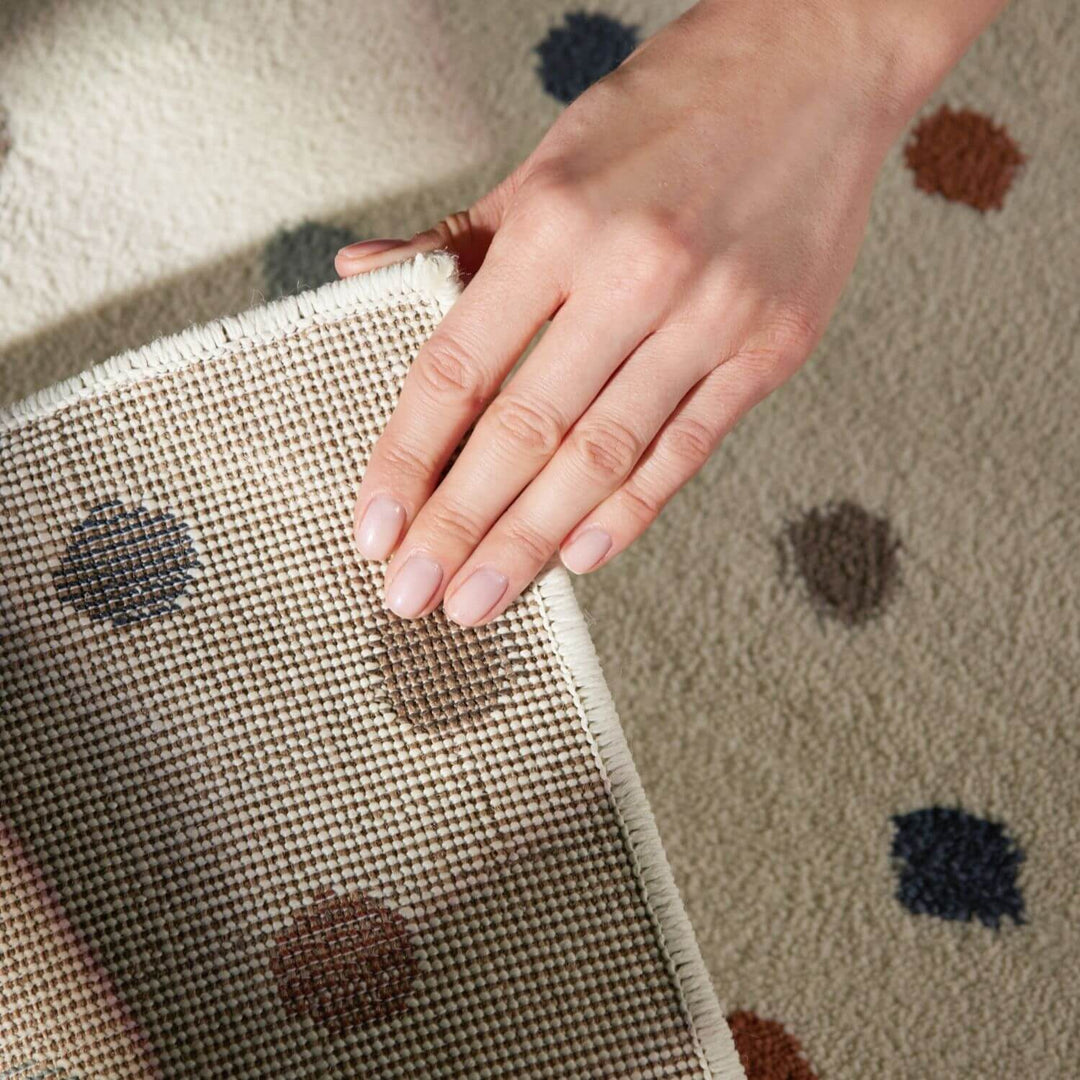 Hand touching a textured fabric surface with a patterned background