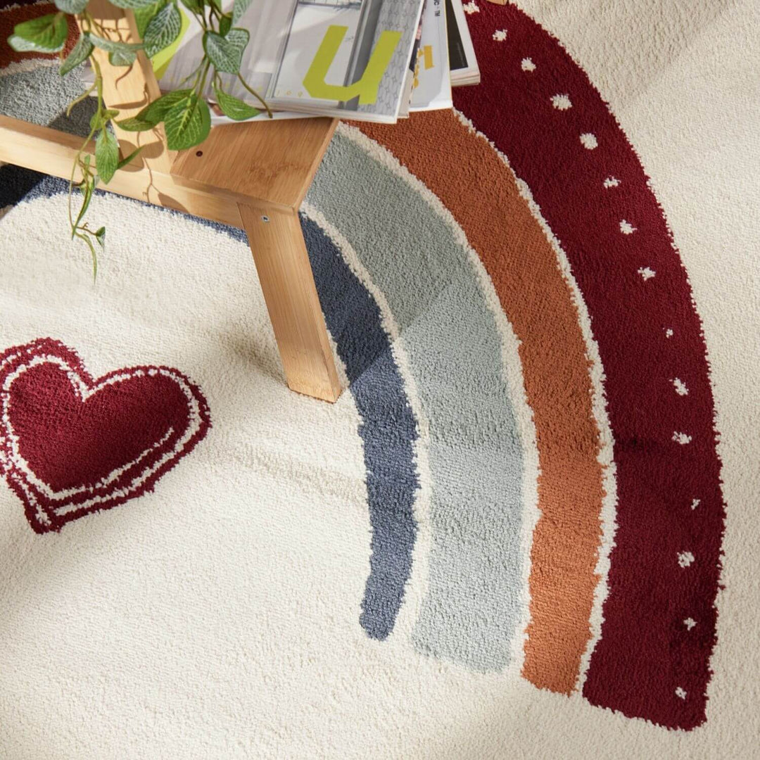 Decorative rug with a rainbow design and heart shape on a neutral background