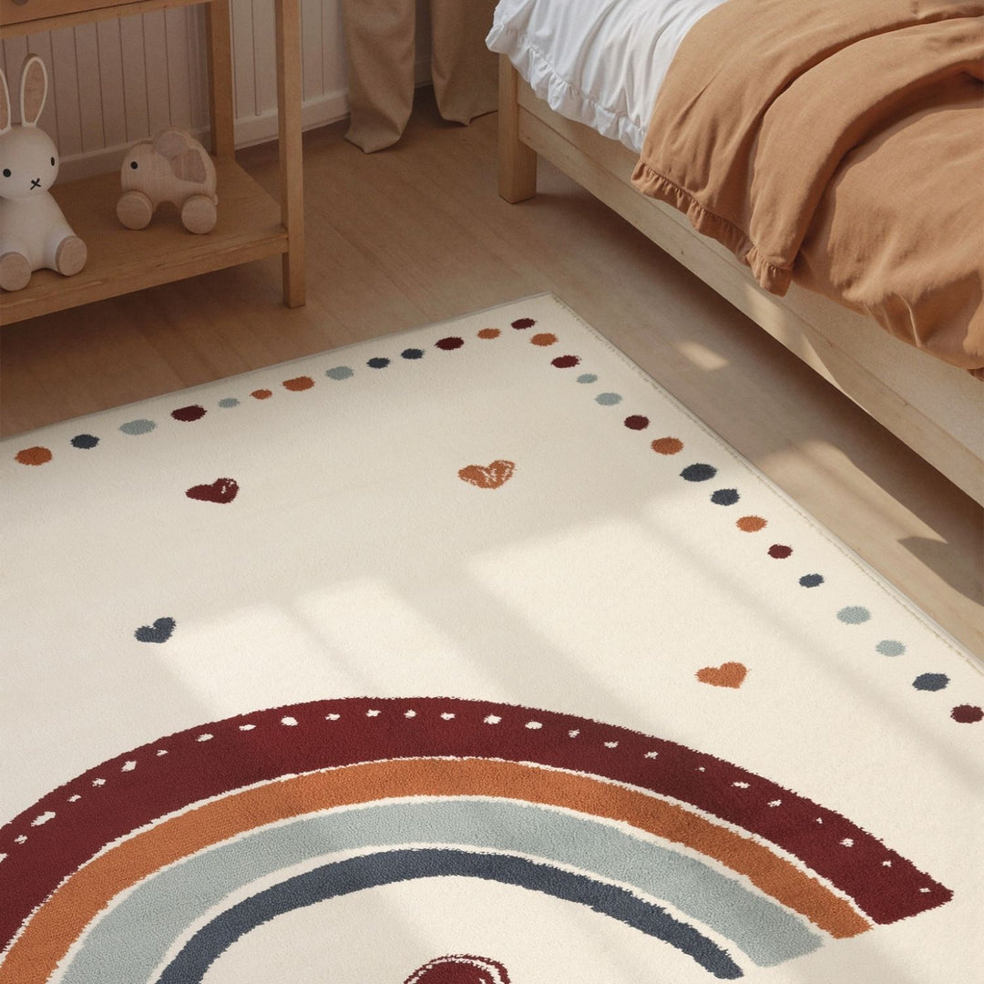 Children's room with a rainbow rug on the floor.