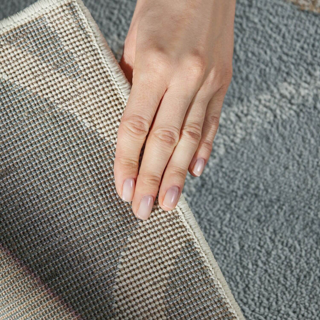 Hand touching a textured surface with a neutral color palette