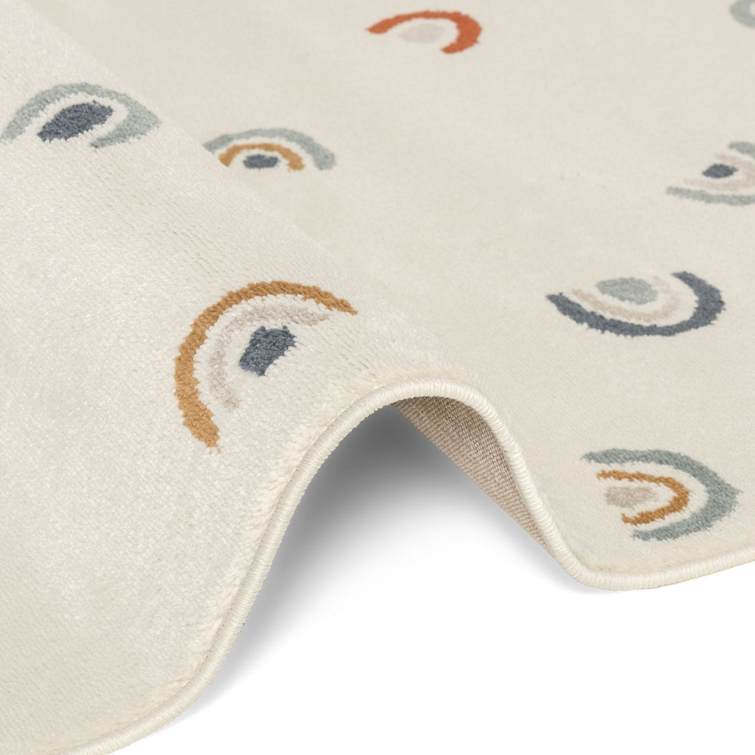 Beige bath mat with rainbow pattern on a white background