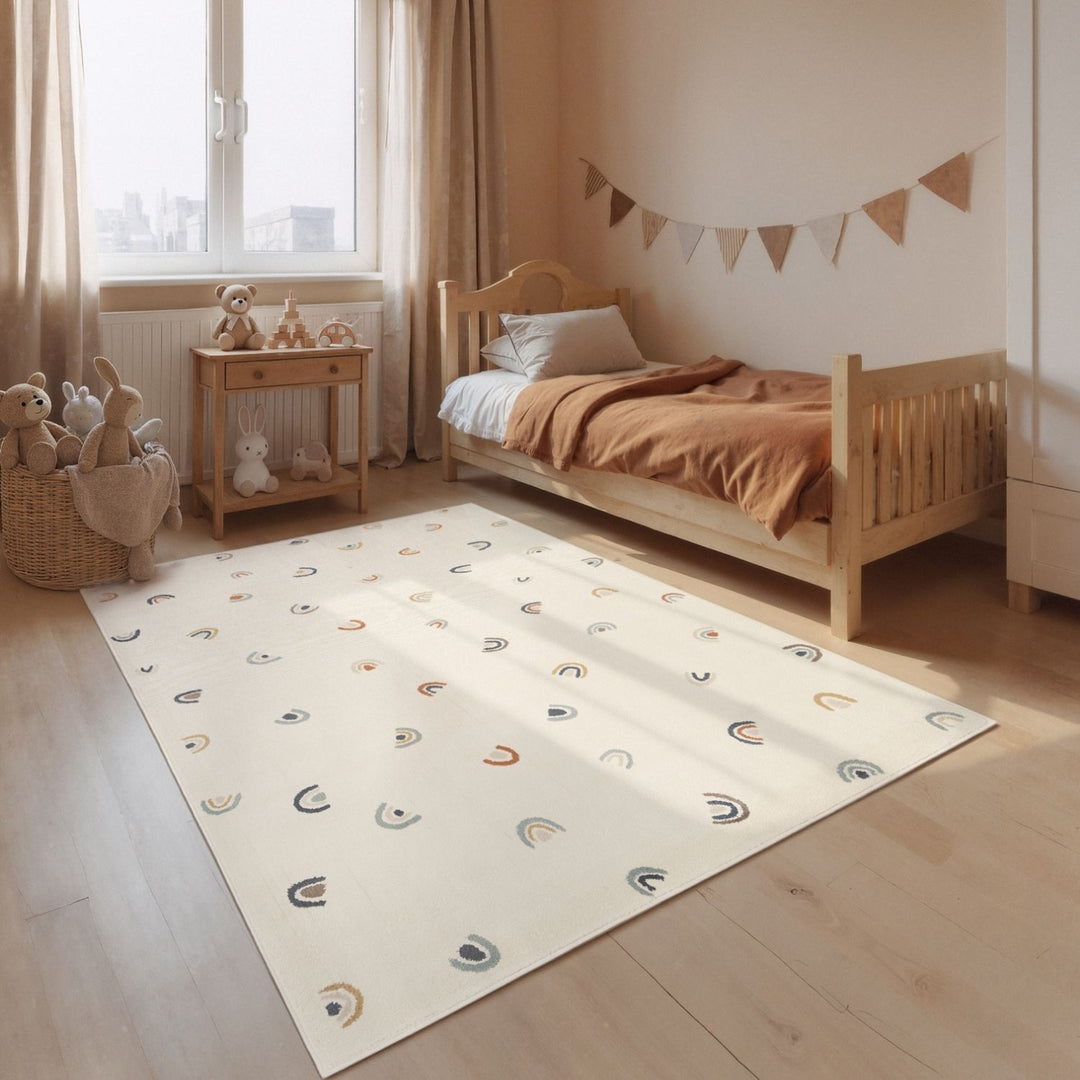 Children's room with a bed, toys, and a patterned rug.
