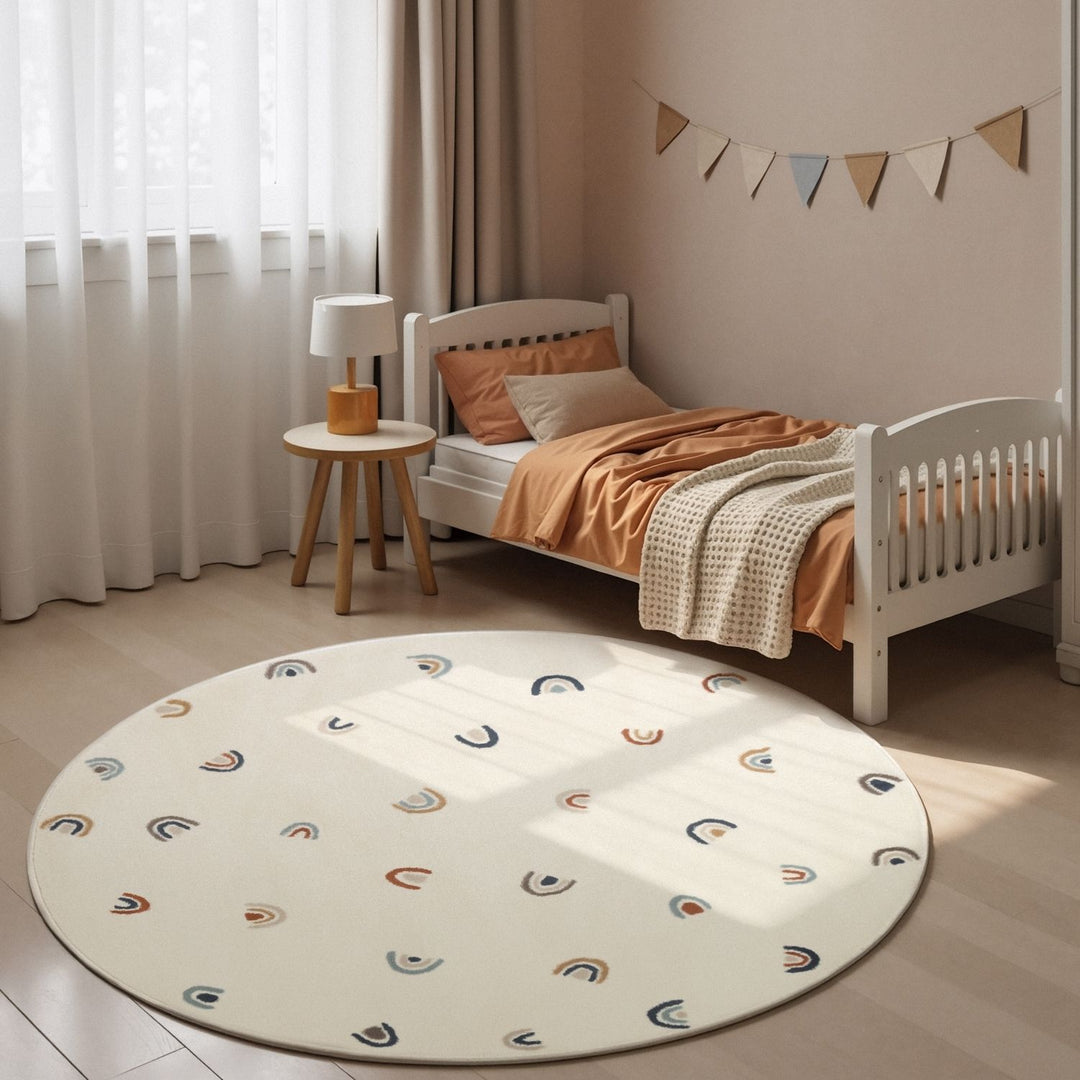 Children's bedroom with a round rug, bed, and small table.