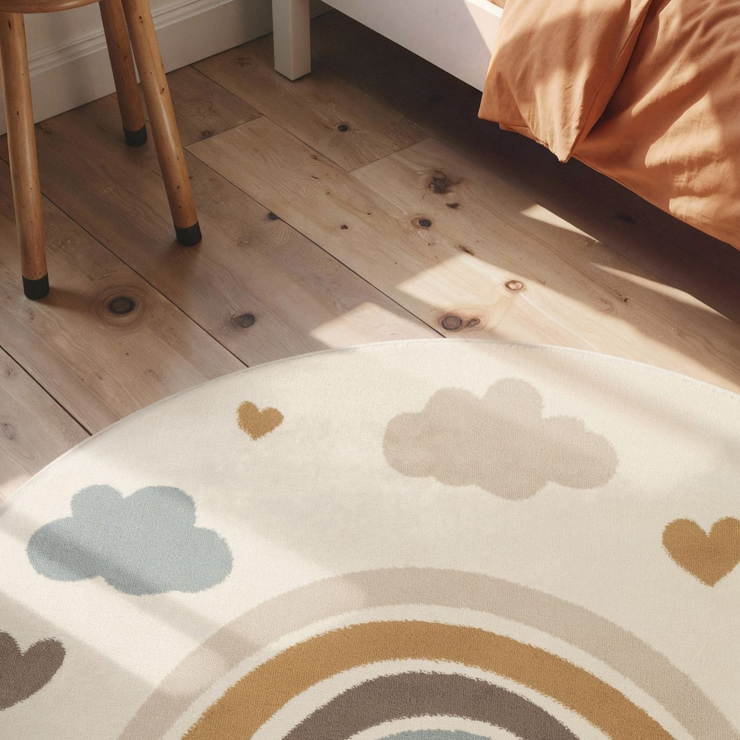 Children's rug with rainbow and cloud patterns on a wooden floor.