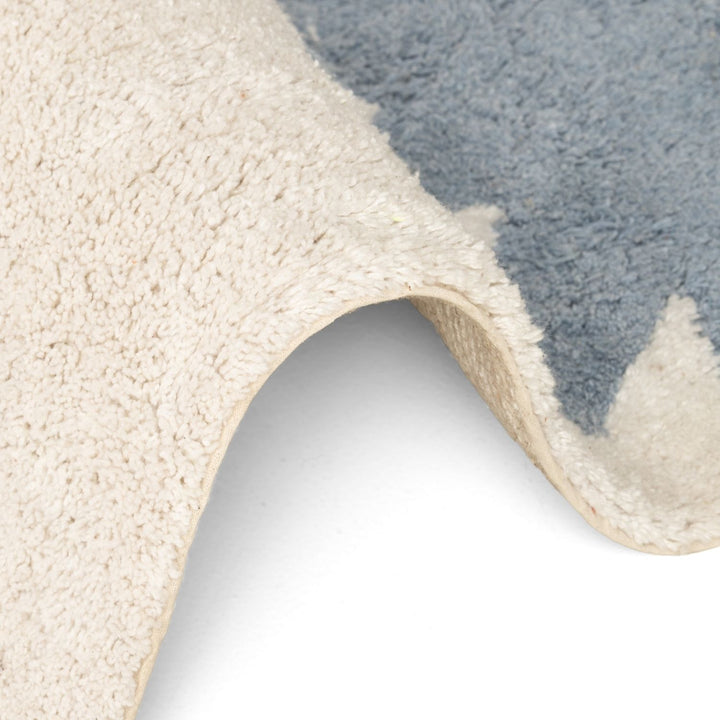 Close-up of a textured rug with a neutral color palette.