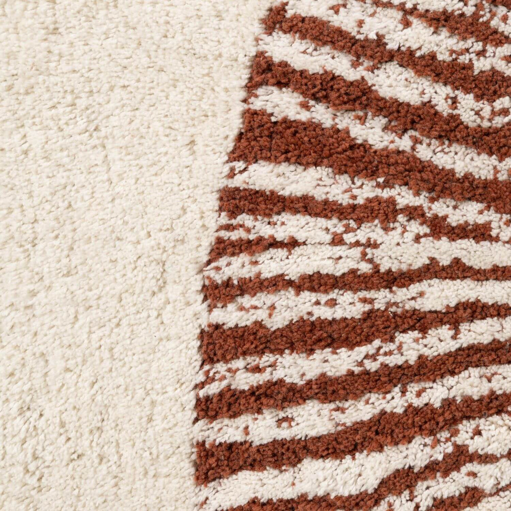 Close-up of a textured rug with brown and white pattern on a beige background