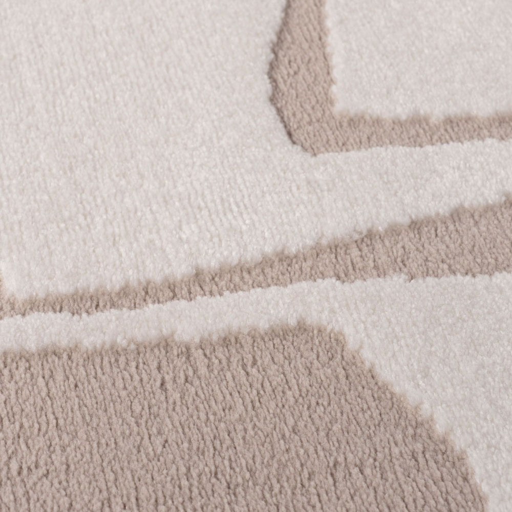 Close-up of a textured rug with geometric pattern in beige and white.