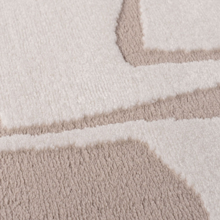 Close-up of a textured rug with geometric pattern in beige and white.