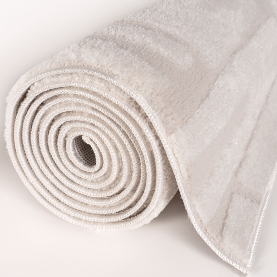 Rolled-up beige yoga mat on a light gray background