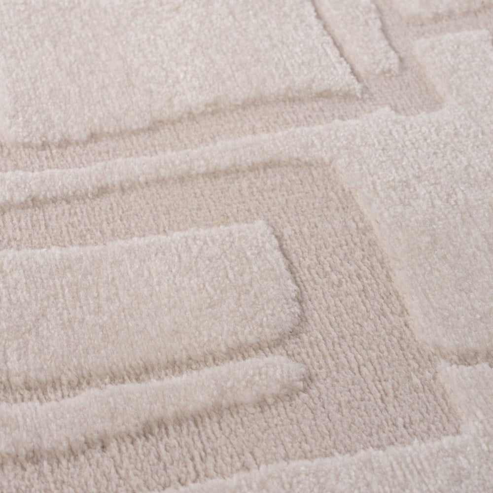 Close-up of a textured beige rug with a geometric pattern