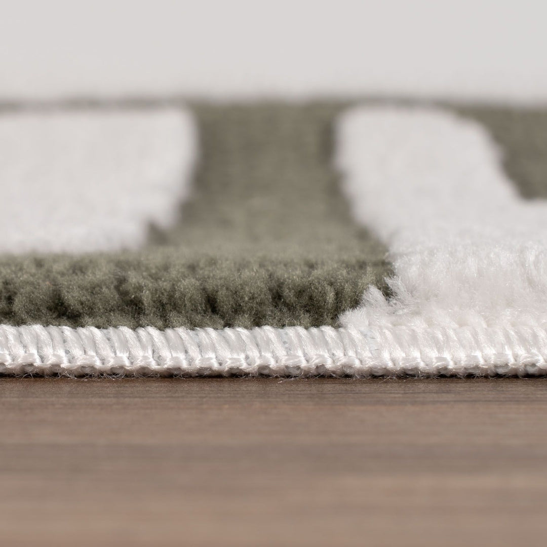 Close-up of a textured rug with a neutral color palette on a wooden floor.