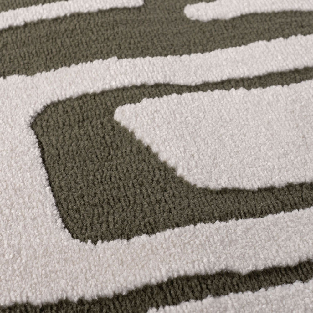Close-up of a textured rug with wavy pattern in green and white