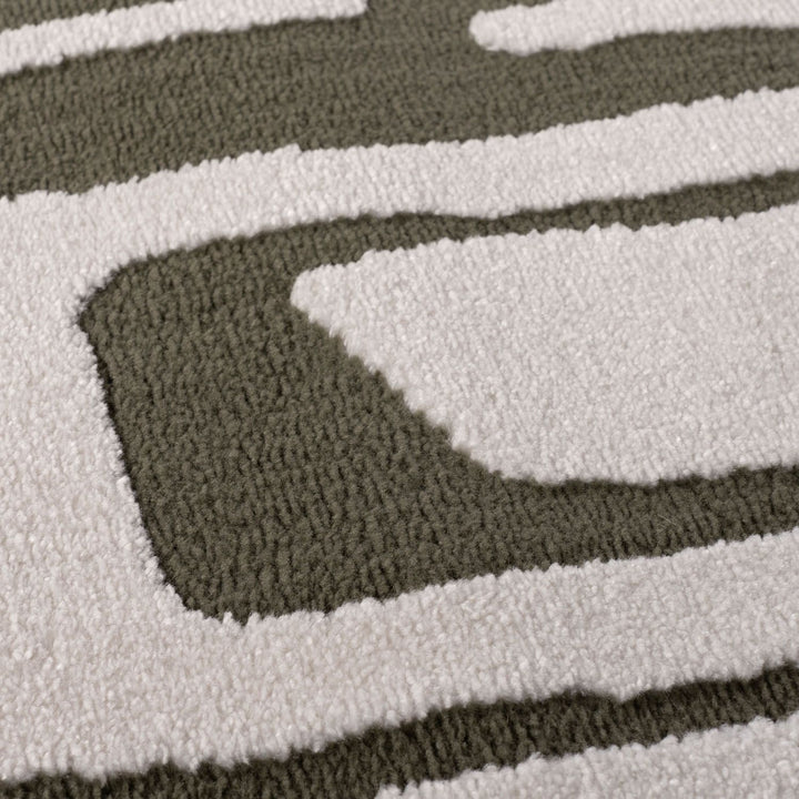 Close-up of a textured rug with wavy pattern in green and white
