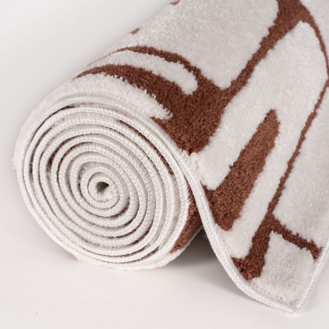 Rolled-up towel with brown abstract pattern on a light background