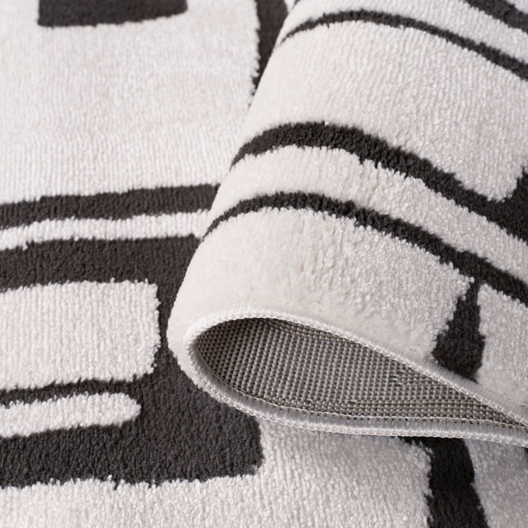 Close-up of a textured rug with black and white stripes