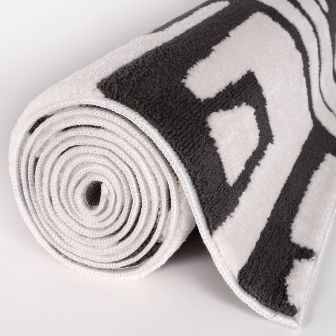 Roll of black and white patterned tape on a light gray background