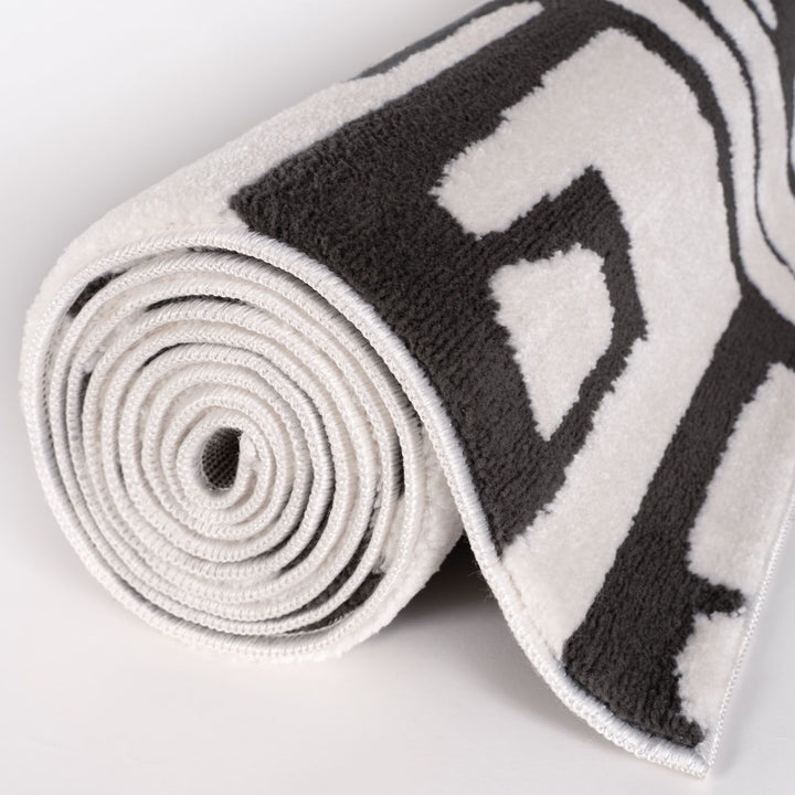 Roll of black and white patterned tape on a light gray background