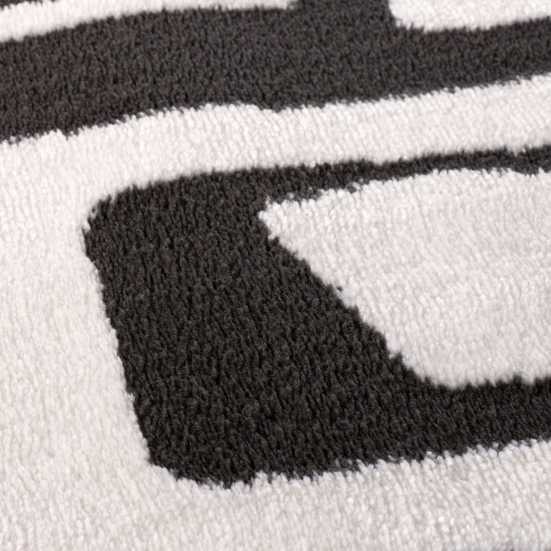 Close-up of a black and white patterned rug with geometric shapes.
