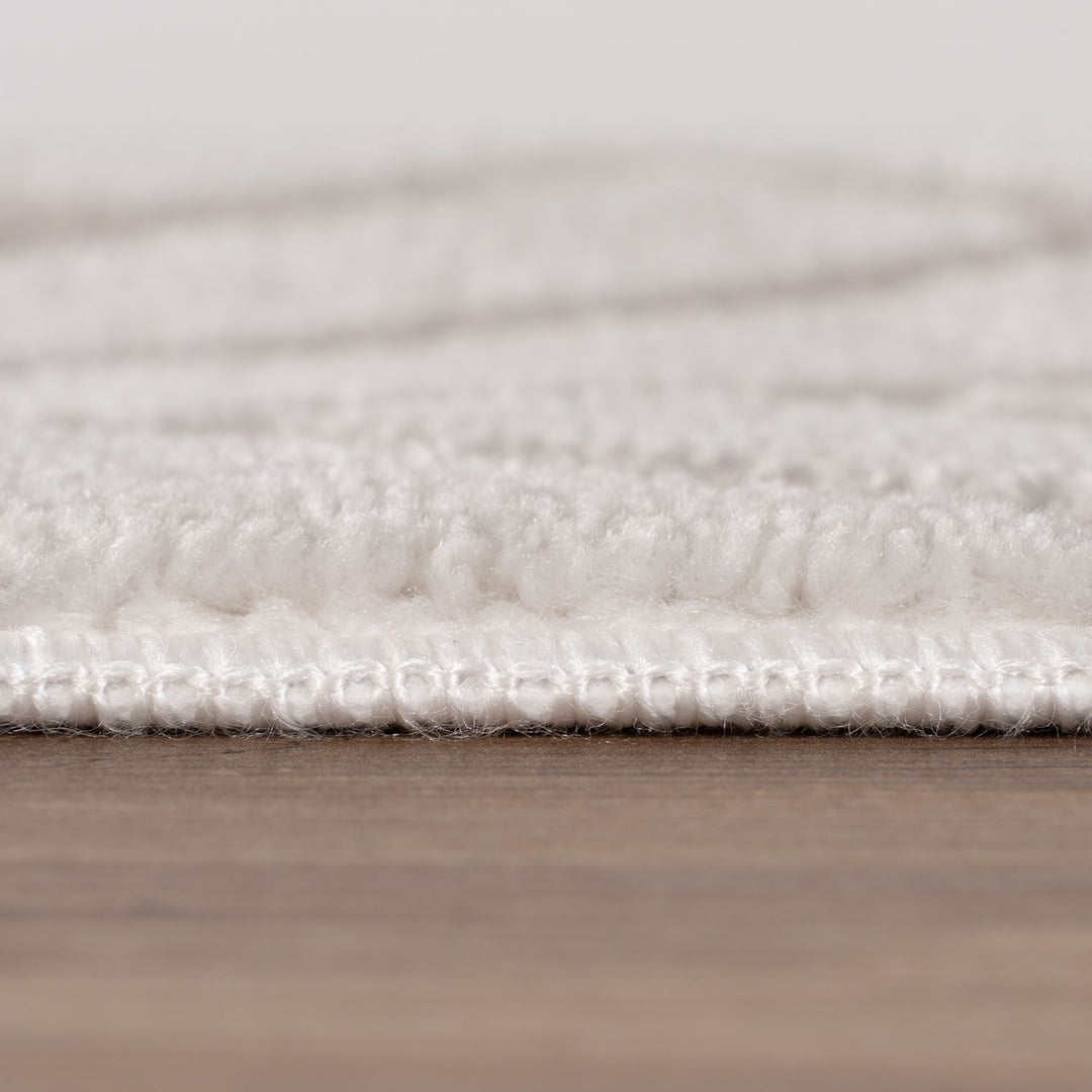 Close-up of a textured white rug on a wooden floor