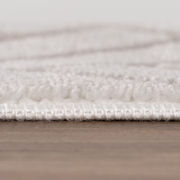 Close-up of a textured white rug on a wooden floor