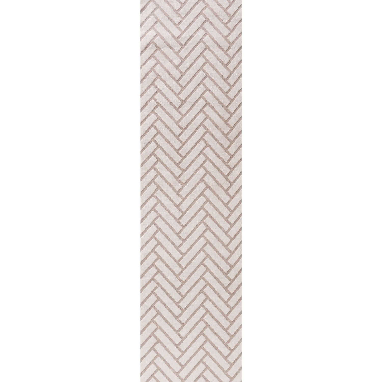 Beige and white geometric patterned rug on a plain background