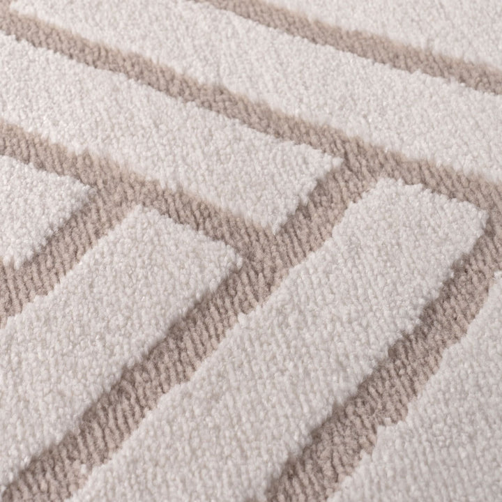 Close-up of a textured rug with a geometric pattern in beige and white.
