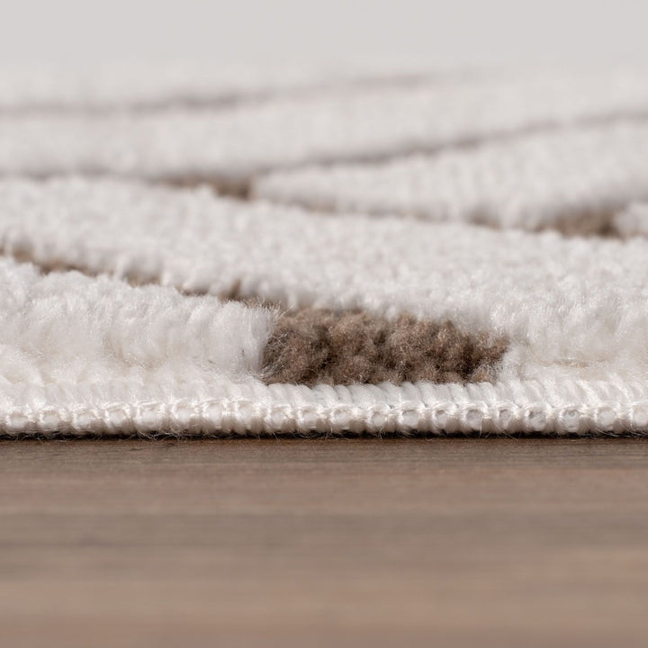Close-up of a textured rug with a neutral color palette on a wooden floor.